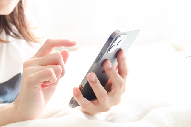 奄美ツアーズ　スマホを触る女性