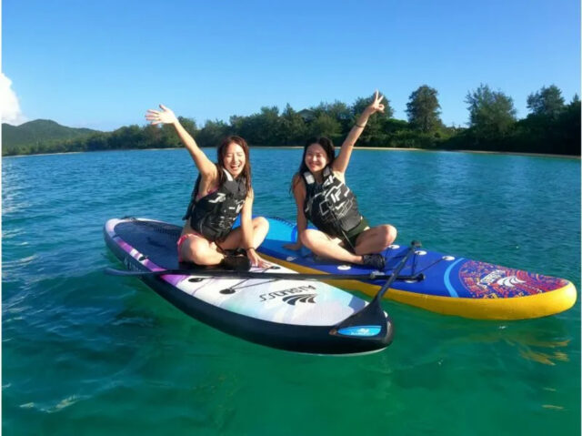 奄美大島のマリンアクティビティ、SUPのボード上でリラックスして楽しむ参加者