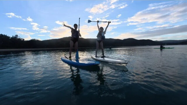 奄美大島の海の上でSUP完走を喜ぶ参加者。思い出に残るアクティビティ体験