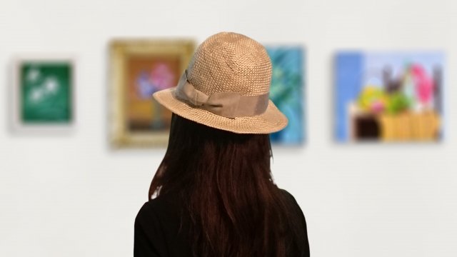  美術館で絵を見る女性の後姿